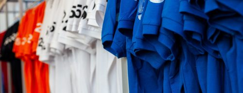 vista-de-coloridas-camisetas-en-perchas-expuestas-en-una-tienda-de-ropa